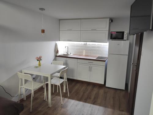 a kitchen with a white refrigerator and a table and chairs at Kossuth Garden in Debrecen