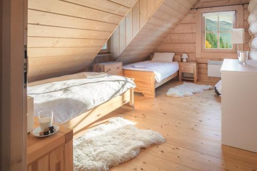 コシチェリスコにあるNydala Rusticの木造キャビン内のベッドルーム1室(ベッド2台付)