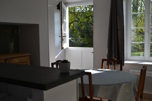 une cuisine avec une table, une fenêtre, une table et des chaises dans l'établissement Appartement 1 chambre à la campagne à 6 km de Wimereux, à Pernes-lès-Boulogne