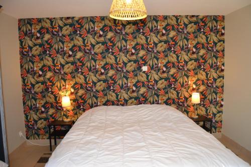 - une chambre avec un lit et un mur recouvert de papier peint dans l'établissement Appartement 1 chambre à la campagne à 6 km de Wimereux, à Pernes-lès-Boulogne