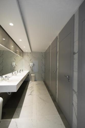 a bathroom with two sinks and a large mirror at Te'Dreri - Llogora Tourist Village in Dhërmi