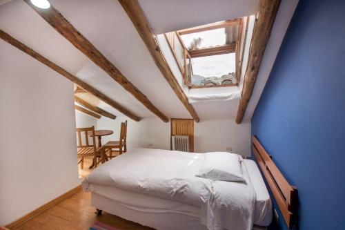 una camera con letto e soffitto con finestra di SAUCE Hotel Boutique a Ollantaytambo