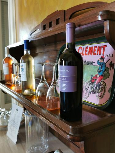 two bottles of wine and glasses on a shelf at Chez Moi Charme B&B in Lecce