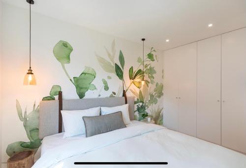 ein Schlafzimmer mit einem weißen Bett mit Pflanzen an der Wand in der Unterkunft Lemon Tree Family Apartment in Porto