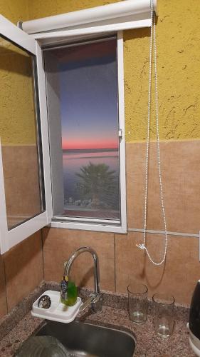a sink and a window with a view of the ocean at Amanecer Petit in Miramar