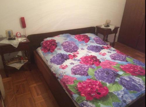 a bed with a quilt with flowers on it at Room in apartment with a host in the center of Bar in Bar