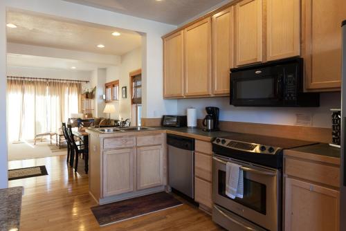 a kitchen with stainless steel appliances and wooden cabinets at Pet Friendly Venturi BBQ on the Deck in Hood River