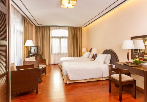 Habitación de hotel con cama y escritorio en Garco Dragon Hotel en Hanoi