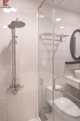 a bathroom with a toilet and a glass shower at TTR Skypool View Hotel in Da Lat