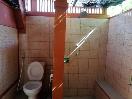 een kleine badkamer met een toilet en een douche bij Lombok Sunset Hideaway in Lembar