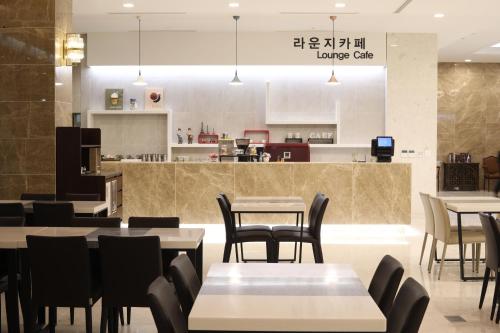 a restaurant with tables and chairs and a counter at The K Jirisan Family Hotel in Gurye