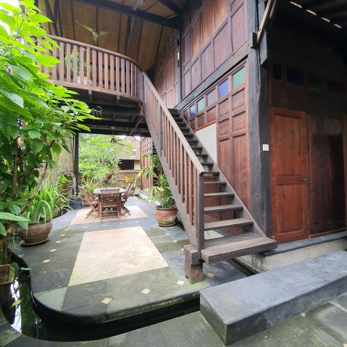 a wooden staircase leading to a house with a table at Yabbiekayu in Yogyakarta