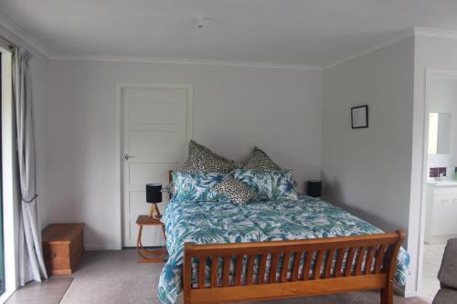 um quarto com uma cama com lençóis e almofadas azuis em Aramatai Gardens em Te Kuiti