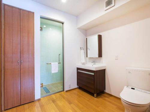Un baño con inodoro, lavabo y ducha. en Kita Kitsune Chalet, en Kutchan