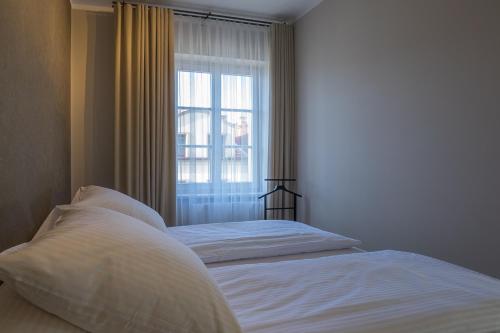1 cama en un dormitorio con ventana en Na Skałce Apartment, en Cracovia