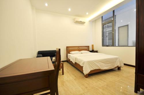 a bedroom with a bed and a desk and a window at Studio apartment Xom Chua in Hanoi