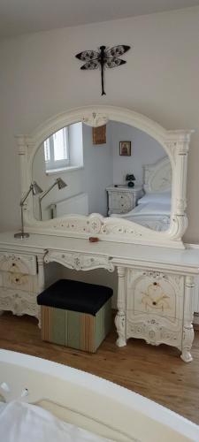 a white bedroom with a bed with a large mirror at Club Canada Lipno De Luxe in Lipno nad Vltavou