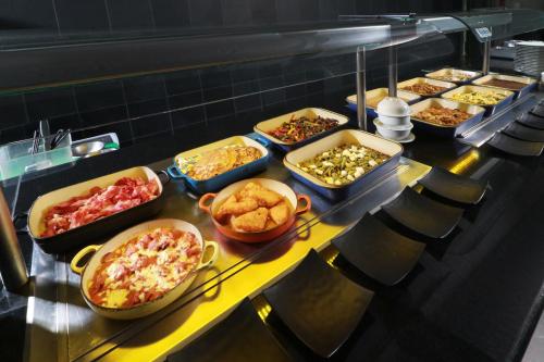 a buffet line with many different types of food at Crowne Plaza Leon by IHG in León