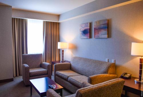 a living room with a couch and chairs in a hotel room at Crowne Plaza Leon by IHG in León