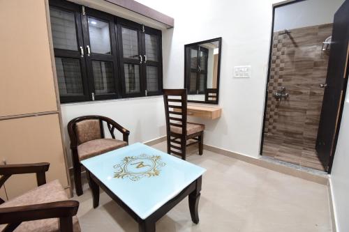 a room with a table and chairs and a window at Advantage Inn in Allahābād