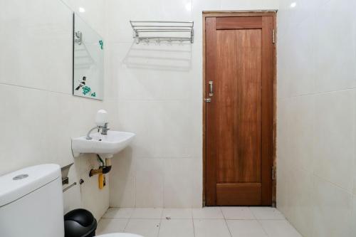 uma casa de banho com um lavatório e uma porta de madeira em Balkondes Duta Menoreh em Magelang