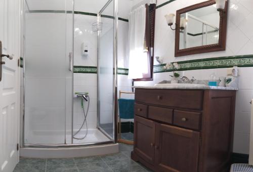 y baño con ducha, lavabo y espejo. en Casa de Tata, en Cue