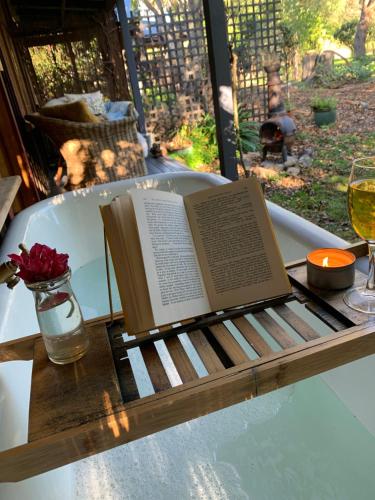 a book on a table with a glass of wine at Quail Farm, Colonial charm in Nelson