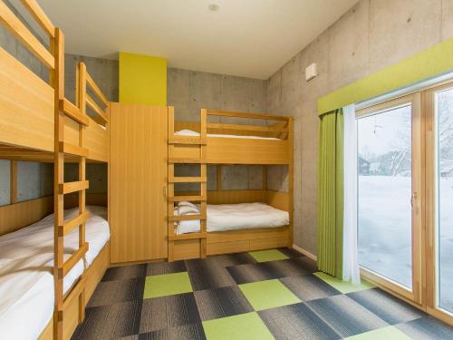 a bunk bed room with two bunk beds and a window at Mizunara Chalet in Niseko