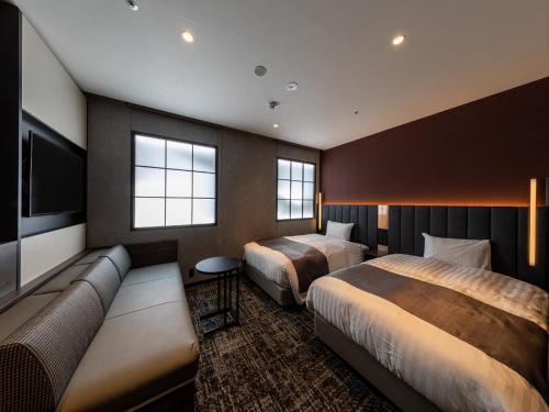 a hotel room with two beds and a couch at Kobe Plaza Hotel in Kobe