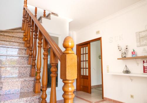 a staircase in a home with a wooden stair case at Solmar Villa in Almada