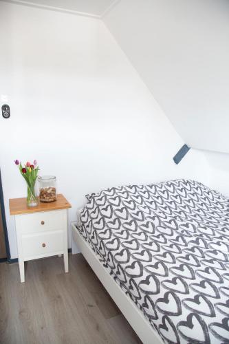 a bedroom with a bed and a table with a vase of flowers at Bed and Wine Nonsolovino in Reeuwijk