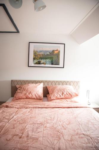 a bedroom with a bed with a pink comforter at Bed and Wine Nonsolovino in Reeuwijk