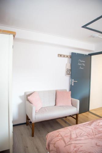 a room with a white couch and a chalkboard at Bed and Wine Nonsolovino in Reeuwijk