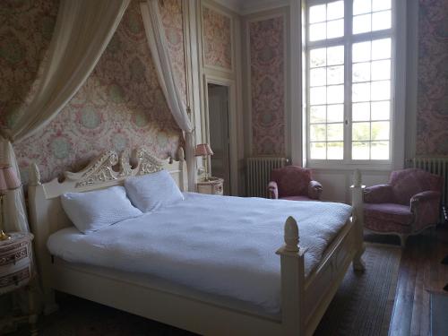a bedroom with a white bed and a window at Chateau du Guérinet D'Orchaise in Orchaise