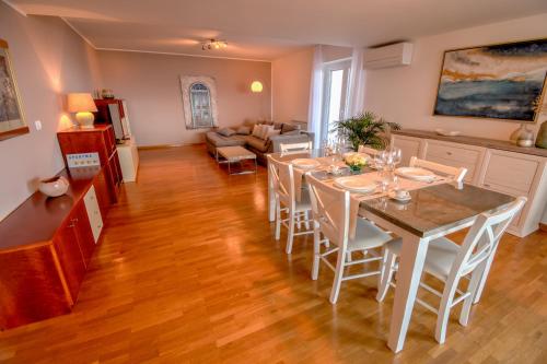 eine Küche und ein Wohnzimmer mit einem Tisch und Stühlen in der Unterkunft Apartma Bellavista in Izola