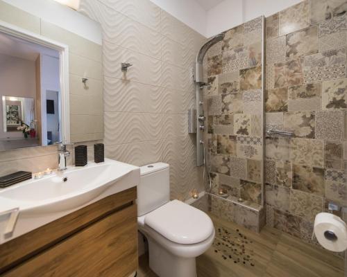a bathroom with a toilet and a sink and a shower at LEFKAS CITY APARTMENTS & Suites in Lefkada Town
