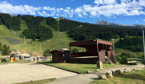 un petit bâtiment avec une montagne en arrière-plan dans l'établissement Studio pied des pistes, à Villard-de-Lans