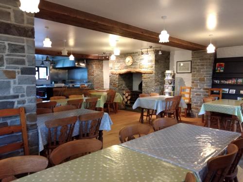 um restaurante com mesas e cadeiras e uma cozinha em Alltyfyrddin Farm Guest House at The Merlin's Hill Centre em Carmarthen
