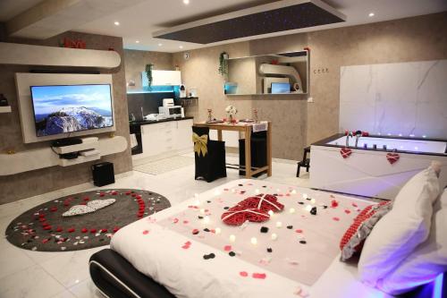 Dreamspa في Audincourt: غرفة نوم بها سرير كبير وعليها زهور حمراء