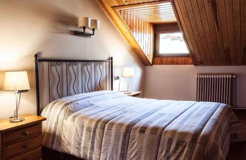 a bedroom with a bed and a wooden ceiling at Hostal La Plaça in Erill la Vall