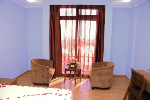 a living room with two chairs and a table and a window at Haile Resort-Gondar in Gonder