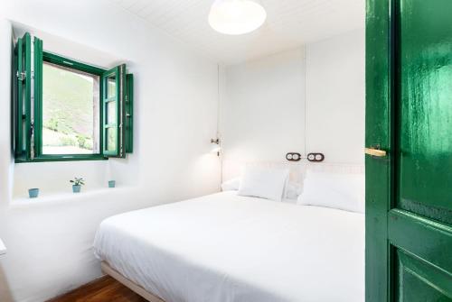 1 dormitorio con cama y puerta verde en Terra Ecoturismo Casa La Casita verde, en La Focella