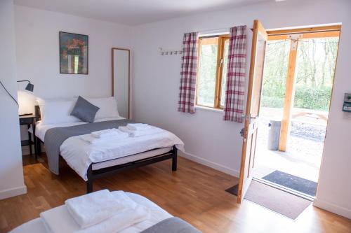 um quarto com 2 camas e uma porta de vidro deslizante em Cowbridge Cabins em Cowbridge