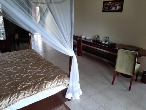 a bedroom with a bed and a desk and a chair at AA Lodge Amboseli in Amboseli