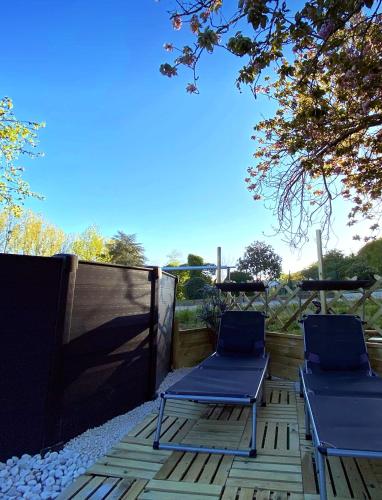 two blue chairs sitting on a patio with a fence at Chez Flo et Marc in Chouzy-sur-Cisse