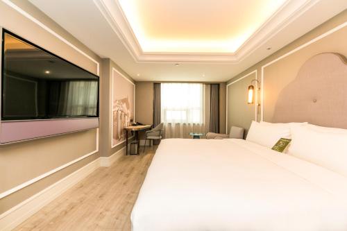 una camera d'albergo con un letto grande e una TV a schermo piatto di Mercure Xian City Centre a Xi'an