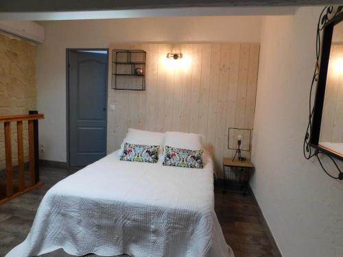 une chambre avec un lit blanc avec deux oreillers dans l'établissement LA MAISON DU LAC climatisée et WiFi gd F3, à Port-la-Nouvelle