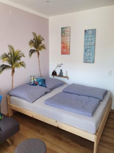 two beds in a bedroom with two palm trees at Fewo Happy Heede in Heede