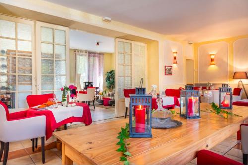 un salon avec une table et des chaises rouges dans l'établissement Au Coeur de Meaulne, à Meaulne
