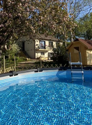 une grande piscine bleue devant une maison dans l'établissement Cottage-Gite & Jacuzzi - Chez Flo & Marc, à Chouzy-sur-Cisse